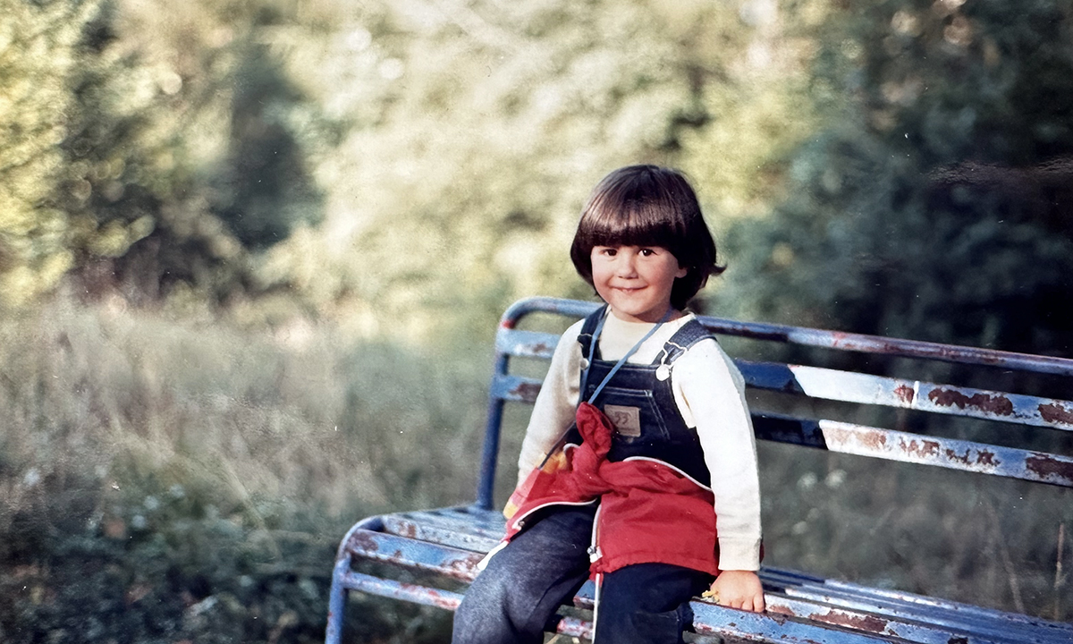 Annalisa da piccola con il binocolo al collo che esplora il bosco